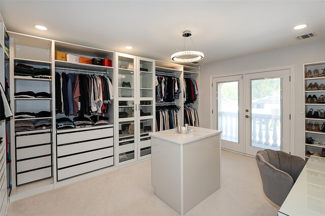 spacious closet with french doors and light carpet