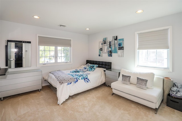 bedroom with light colored carpet and recessed lighting