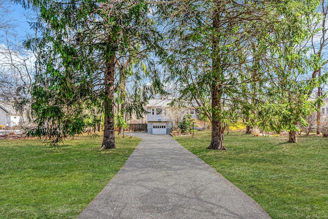 view of front of home featuring an attached garage, driveway, and a front lawn