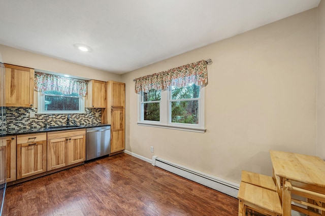 kitchen with a sink, dark wood-style flooring, dark countertops, stainless steel dishwasher, and a baseboard heating unit
