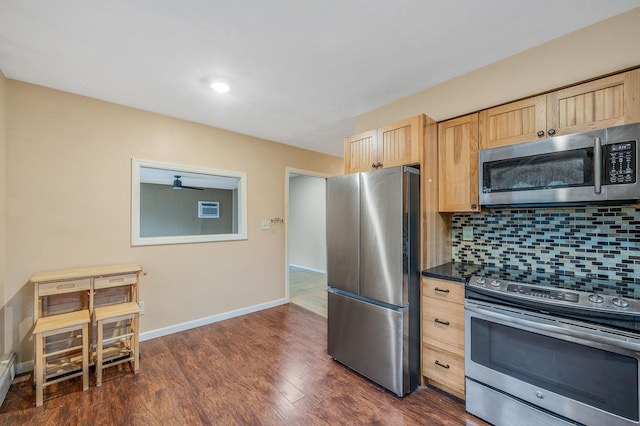 kitchen featuring tasteful backsplash, light brown cabinets, dark countertops, dark wood finished floors, and stainless steel appliances