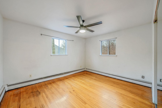 spare room with a ceiling fan, a baseboard heating unit, and wood finished floors