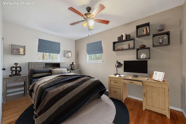 bedroom with ceiling fan, multiple windows, baseboards, and light wood finished floors