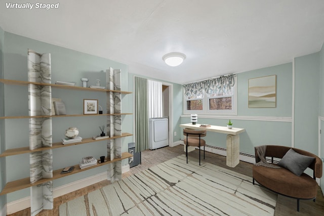 sitting room featuring wood finished floors, baseboards, a baseboard radiator, and washer / clothes dryer