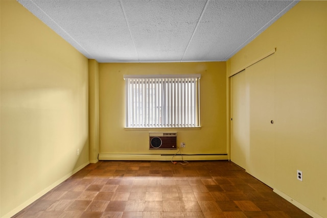 687 Bronx River Rd # 2A, Yonkers, NY 10704 - unfurnished bedroom with a textured ceiling, an AC wall unit, baseboard heating, and a closet