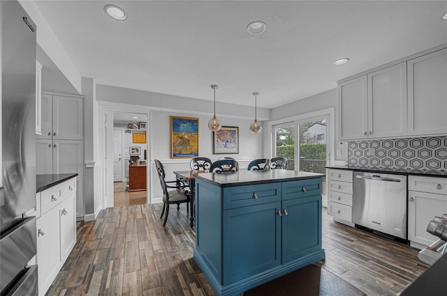 kitchen with dark wood-style floors, dark countertops, and appliances with stainless steel finishes