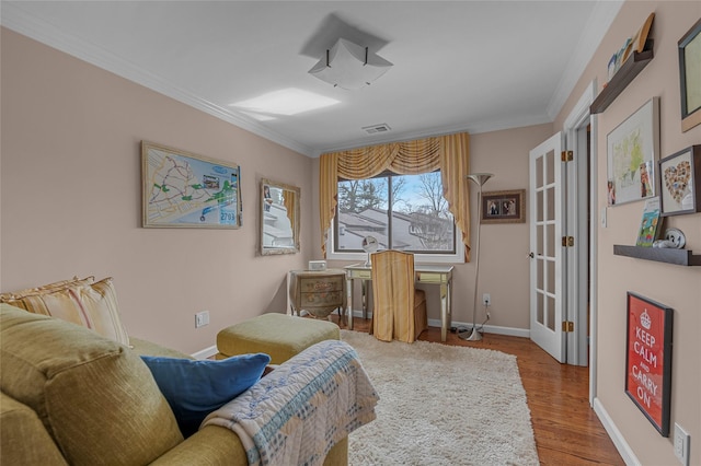 interior space with baseboards, visible vents, wood finished floors, and ornamental molding