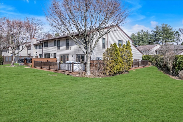 back of house with a wooden deck and a yard