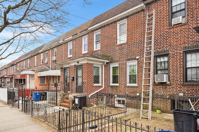 view of front of property with brick siding, fence, and entry steps