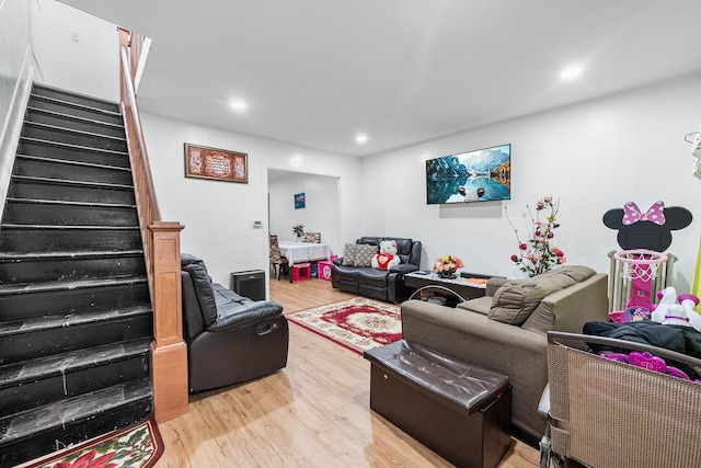 living room featuring recessed lighting, stairs, and light wood-type flooring