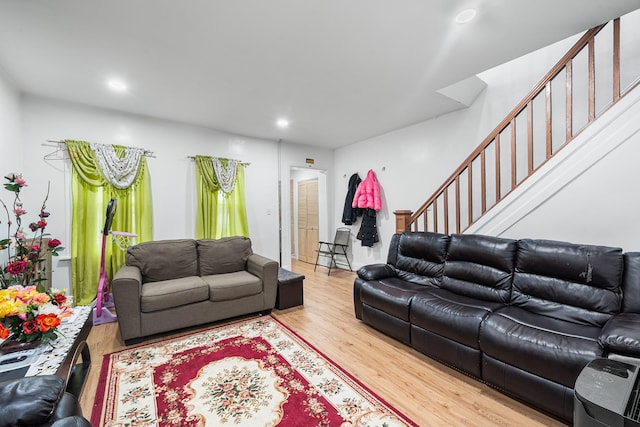 living area with recessed lighting, wood finished floors, and stairway