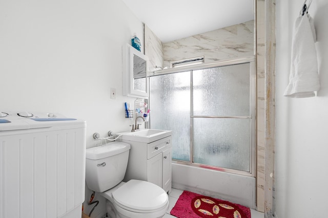 bathroom with bath / shower combo with glass door, toilet, vanity, and washer / dryer