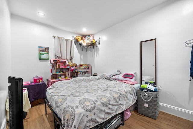 bedroom featuring baseboards, wood finished floors, and recessed lighting