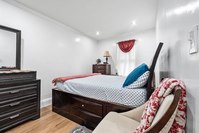 bedroom featuring baseboards, wood finished floors, and recessed lighting