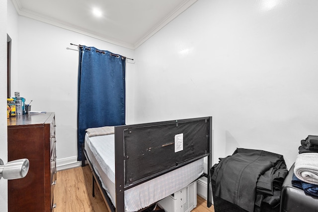 bedroom featuring baseboards, ornamental molding, and light wood-style floors