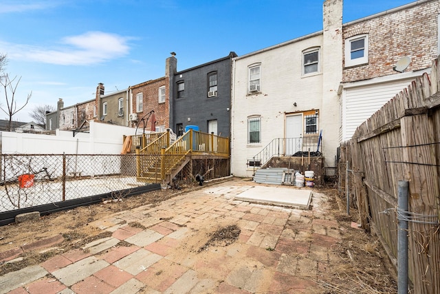 back of house with a fenced backyard and a patio area