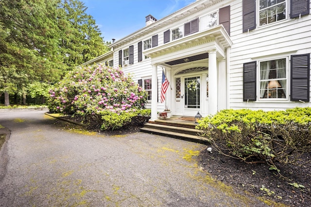 view of exterior entry featuring a chimney