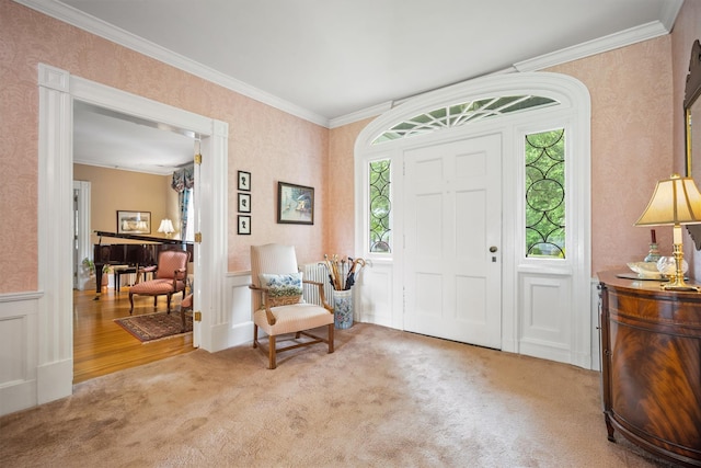 entryway featuring wallpapered walls, ornamental molding, carpet, and wainscoting