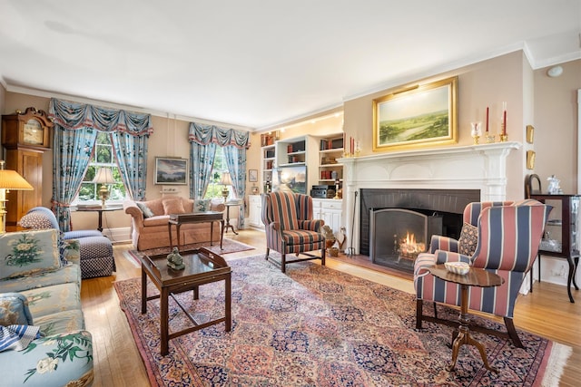 living room featuring a fireplace, ornamental molding, and wood finished floors