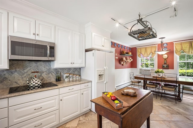 kitchen with crown molding, a baseboard heating unit, stainless steel microwave, a wainscoted wall, and white cabinets