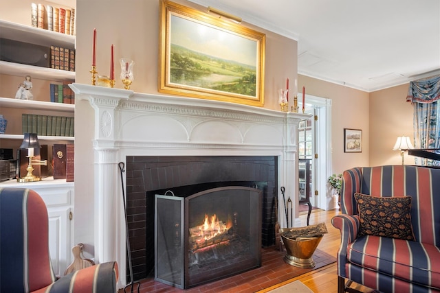 interior details featuring wood finished floors, ornamental molding, and a brick fireplace