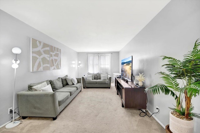 carpeted living area featuring baseboards