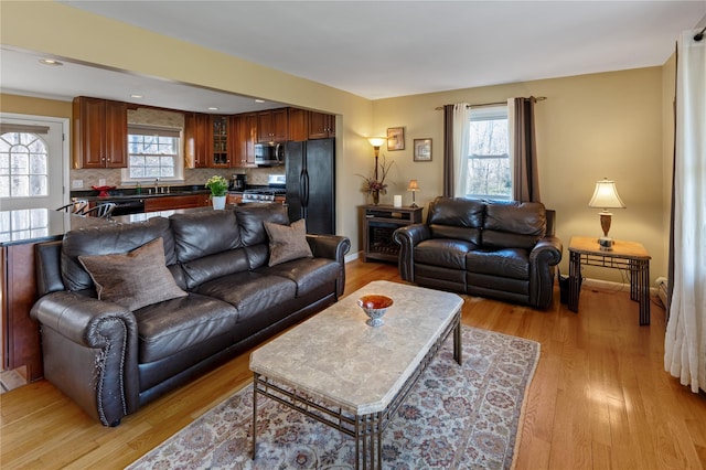 living area featuring light wood-style flooring and baseboards