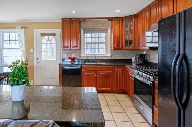 kitchen featuring a sink, backsplash, black appliances, and light tile patterned flooring
