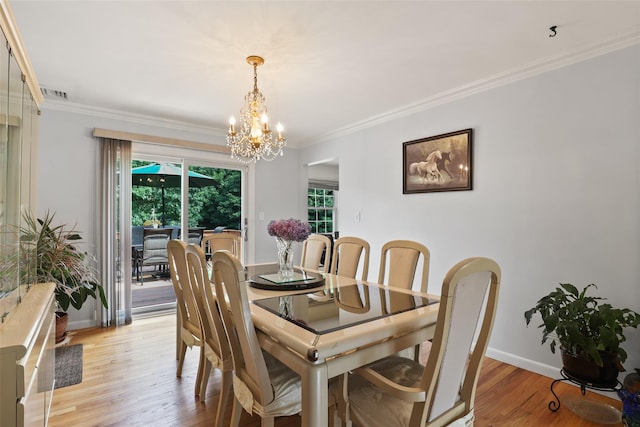 dining space with light wood-style floors, visible vents, ornamental molding, and a chandelier