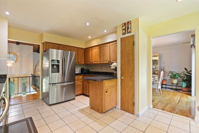 kitchen with stainless steel refrigerator with ice dispenser, recessed lighting, a baseboard heating unit, brown cabinets, and light tile patterned floors