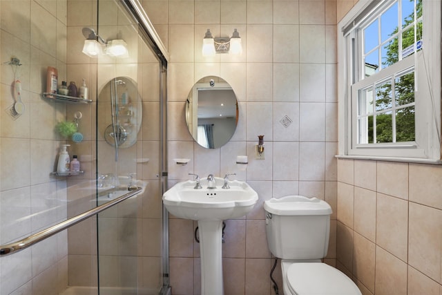 bathroom with tile walls, a stall shower, and toilet