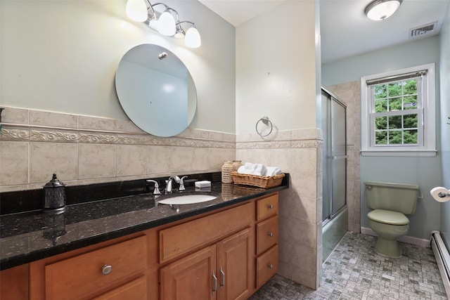 full bathroom with visible vents, vanity, toilet, tile walls, and a baseboard heating unit