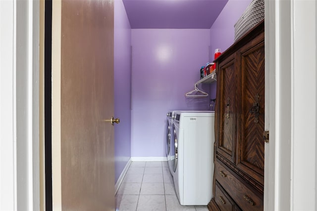 washroom featuring baseboards, laundry area, washing machine and dryer, and light tile patterned flooring
