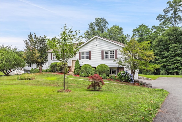 view of front of home with a garage, driveway, and a front lawn