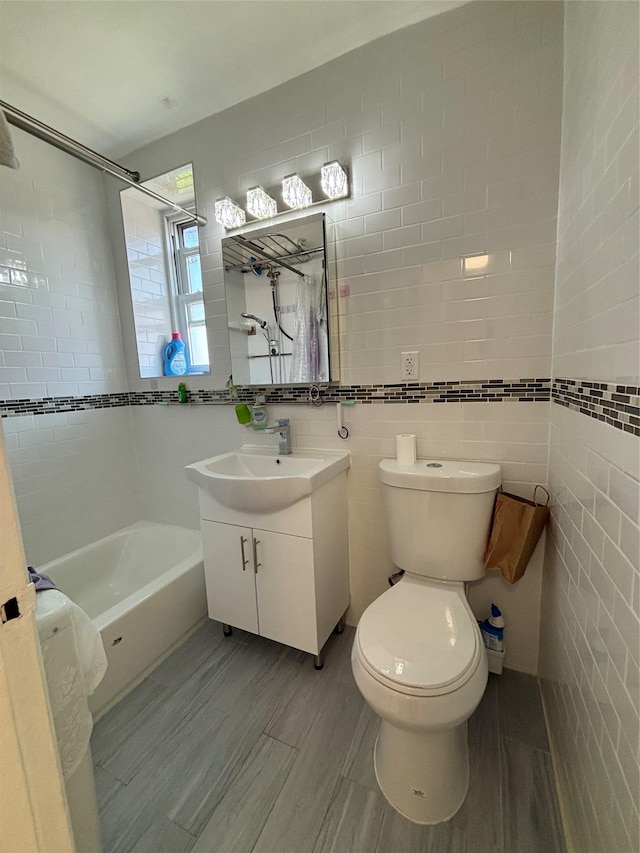 full bathroom with tile walls, toilet, vanity, and tub / shower combination
