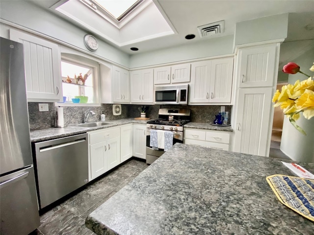 4081 Massachusetts Ave, Island Park, NY 11558 - kitchen featuring visible vents, tasteful backsplash, appliances with stainless steel finishes, white cabinetry, and a sink