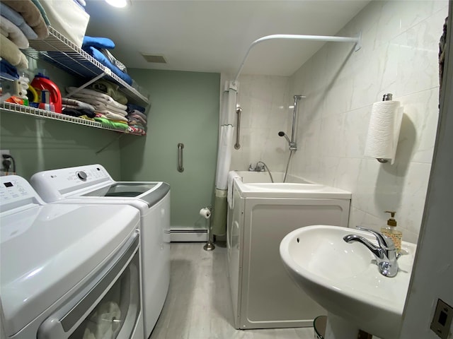 4081 Massachusetts Ave, Island Park, NY 11558 - washroom with washer and clothes dryer, a sink, a baseboard radiator, laundry area, and visible vents