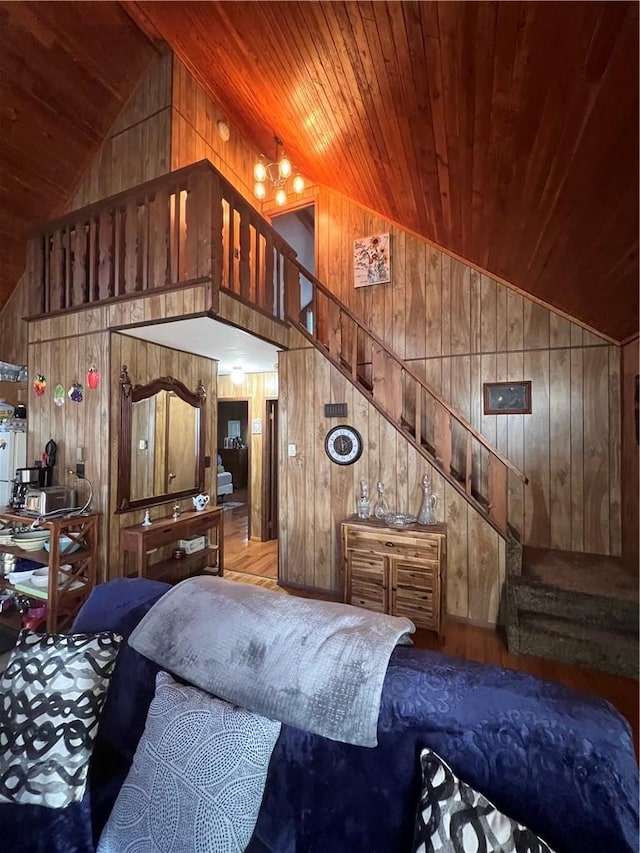 bedroom with wood ceiling, high vaulted ceiling, and wooden walls