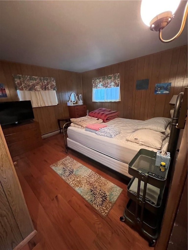 bedroom featuring wood finished floors and wood walls