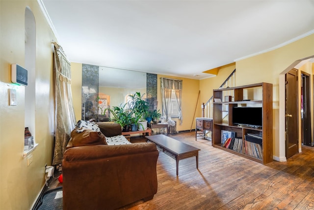 living room with arched walkways, ornamental molding, and wood-type flooring