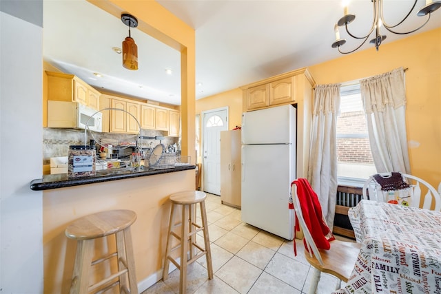 kitchen with decorative backsplash, light tile patterned flooring, a chandelier, white appliances, and light brown cabinets