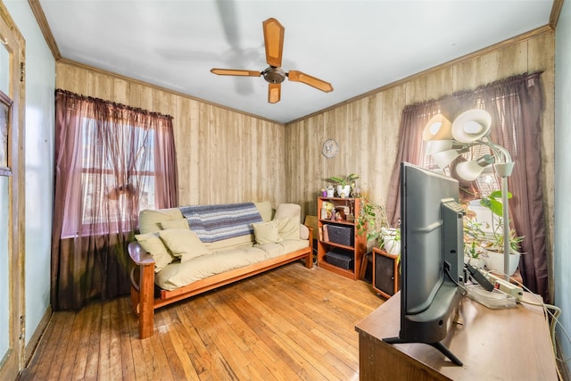 living area with hardwood / wood-style flooring, crown molding, and ceiling fan