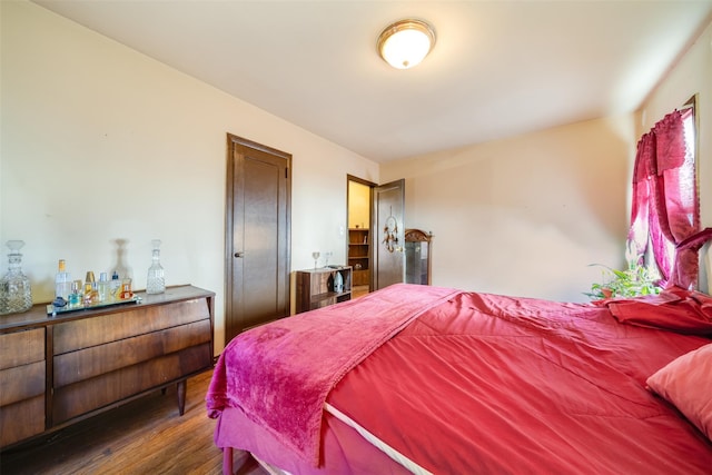 bedroom featuring dark wood finished floors and a dry bar