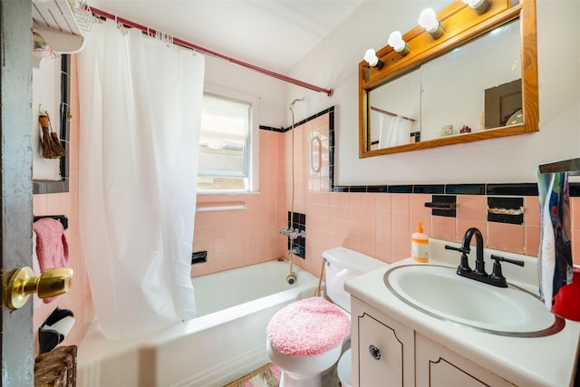 bathroom with toilet, vanity, shower / tub combo, and tile walls