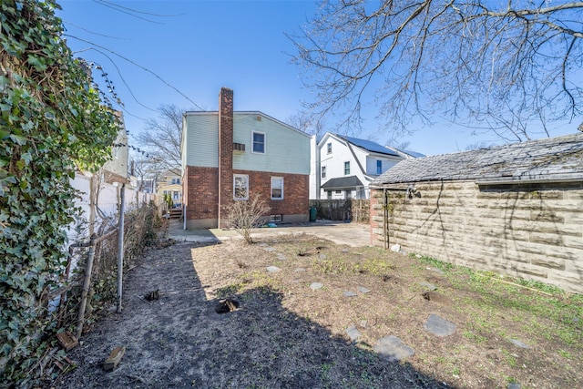 back of house with a patio, brick siding, and a fenced backyard