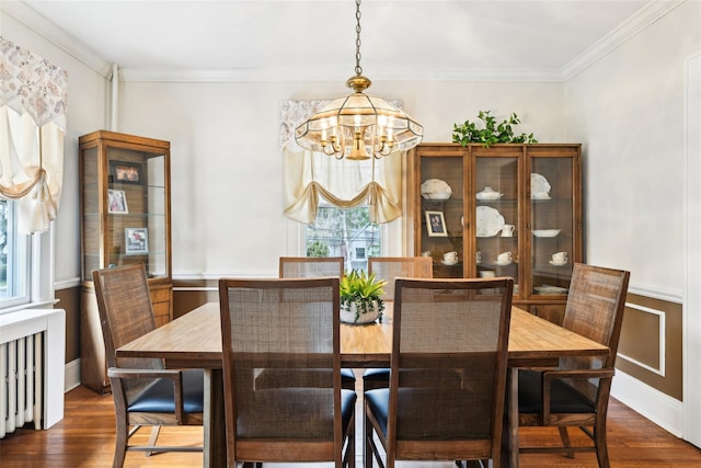 36 Seaview Ave, Northport, NY 11768 - dining area featuring dark wood-type flooring, ornamental molding, an inviting chandelier, and radiator