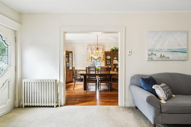 36 Seaview Ave, Northport, NY 11768 - carpeted living area with a notable chandelier, crown molding, radiator heating unit, and a healthy amount of sunlight