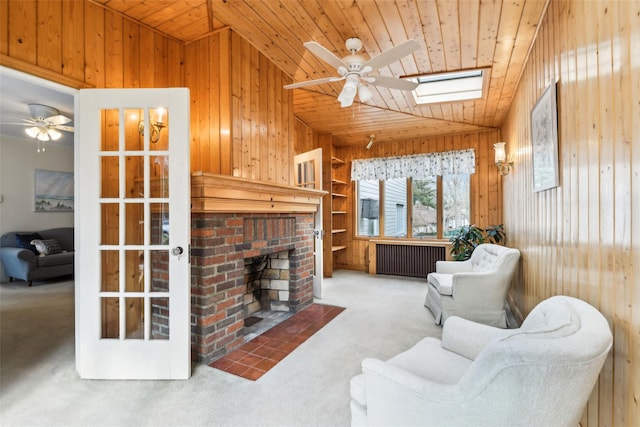 36 Seaview Ave, Northport, NY 11768 - living room featuring wooden walls, ceiling fan, vaulted ceiling with skylight, radiator, and wooden ceiling