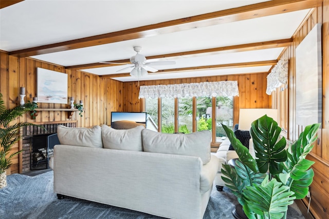 36 Seaview Ave, Northport, NY 11768 - living room with wooden walls, beamed ceiling, a fireplace, a ceiling fan, and carpet floors