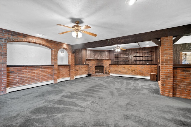 21 Hillside Rd, Slate Hill, NY 10973 - unfurnished living room with a ceiling fan, brick wall, a baseboard heating unit, carpet flooring, and a fireplace with raised hearth